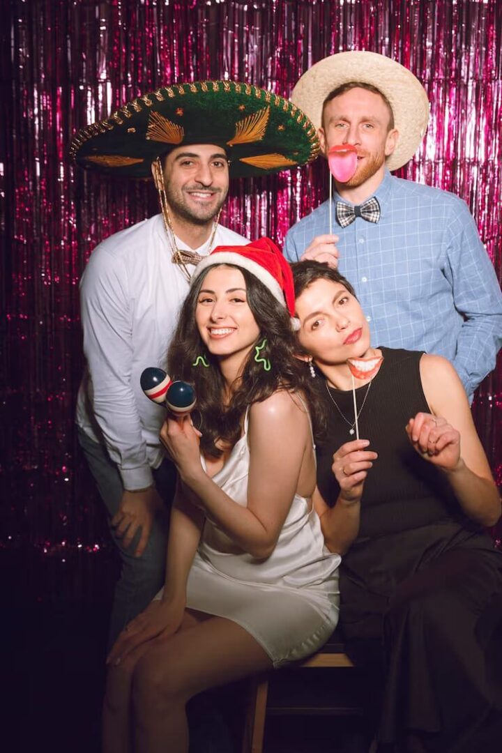 A group of people posing for the camera in front of a pink backdrop.