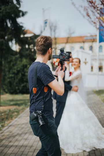 A man holding a camera and taking a picture of a woman.
